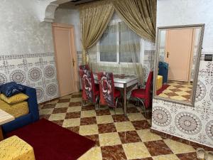 a room with a table and chairs and a mirror at Omarkad in Taourirt