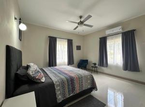 a bedroom with a bed and a ceiling fan at Villa cool breeze in Steer Town