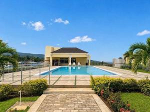 a swimming pool in front of a house at Villa cool breeze in Steer Town