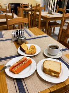 a table with plates of food and a cup of coffee at Hotel ideal 2 in Inocência