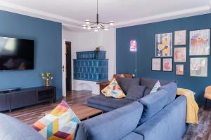 a living room with blue walls and a blue couch at MiHome - Grimming View Apartment in Tauplitz