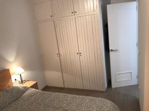 a bedroom with a white closet and a bed at La mestrança in Blanes
