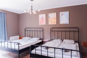 two beds in a room with paintings on the wall at MiHome - Grimming View Apartment in Tauplitz