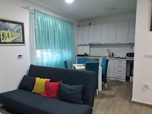 a living room with a couch and a kitchen at Apartman Jass in Stari Banovci