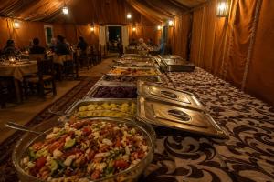 a buffet line of food on a long table at Camp Luxury in Merzouga in Merzouga