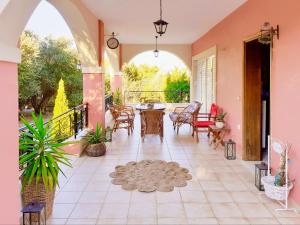 a large patio with a table and chairs and a large window at Villa Valia Seaside in Ipsos +38 photos