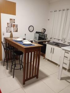a kitchen with a table and some chairs and a microwave at Suíte Completa in Barra Velha