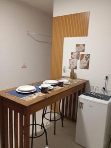 a kitchen with a wooden table with plates on it at Suíte Completa in Barra Velha