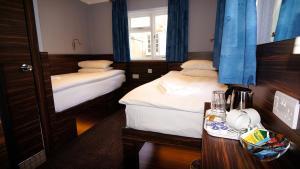 Kleines Zimmer mit 2 Betten und einem Tisch in der Unterkunft Crestfield Hotel in London