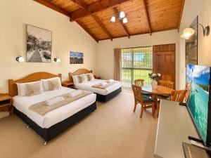 a bedroom with two beds and a dining room at Coonawarra Place Motor Inn in Coonawarra