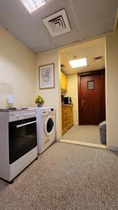 a kitchen with a washing machine and a washer at MBZ - Boutique Bed Space in Muşaffaḩ