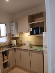 a kitchen with white cabinets and a counter top at Punto Sur Apart in Río Cuarto