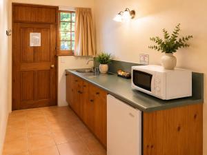 a kitchen with a microwave on top of a counter at Coonawarra Place Motor Inn in Coonawarra