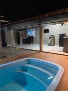 ein großer blauer Swimmingpool vor einer Bühne in der Unterkunft Espaço Vida Nova in Lins