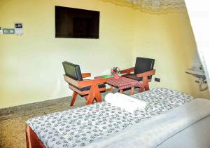 a room with two beds and a table and chairs at Safari Resot Star One in Moshi