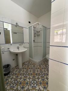 a white bathroom with a sink and a shower at Belvedere Blu b&b & beach in Belvedere Marittimo