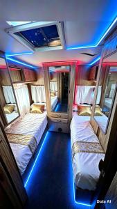 two beds in a small room with blue lights at White Queen in El Paredón Buena Vista