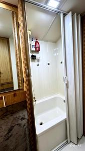 a bath tub in a bathroom with a large mirror at White Queen in El Paredón Buena Vista