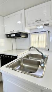 a kitchen with a stainless steel sink and white cabinets at White Queen in El Paredón Buena Vista