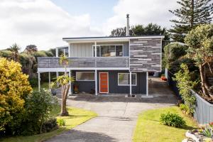 a house with a blue and gray facade at Waikanae Beach Suite Retreat in Waikanae
