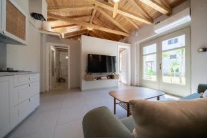 a living room with a couch and a table at Meraki Seaside Suite Pelion in Kalamos
