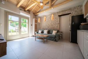 a living room with a couch and a table at Meraki Seaside Suite Pelion in Kalamos