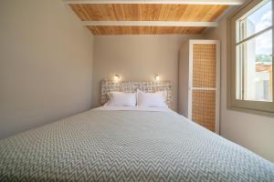 a bedroom with a large bed with a wooden ceiling at Meraki Seaside Suite Pelion in Kalamos