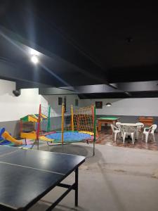 a room with a ping pong table and play equipment at Ita Green in Teresópolis