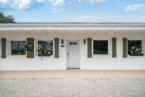 a white house with windows and a white door at Cashmere Private Studio Cozy Chic Escape in Kokomo