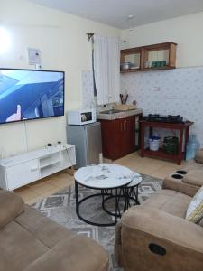 a living room with a tv and a couch and a table at Lex homes in Mombasa