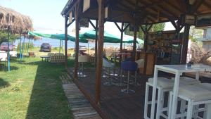 a wooden deck with chairs and tables and umbrellas at Camper Park Lake View in Mëmëlisht +3 photos