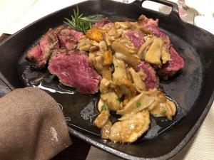 a plate of food with meat on a table at Villa Martina Luxury Suites Como Lake in Lecco