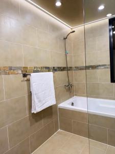 a bathroom with a shower and a tub and a towel at Fabulous Room in Muşaffaḩ +6 photos