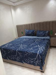a bed with a blue comforter and blue pillows at Ikamat raha in Tangier