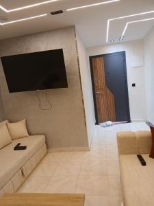 a living room with a couch and a flat screen tv at Ikamat raha in Tangier