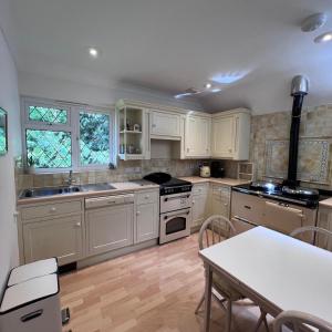 a kitchen with white cabinets and a stove top oven at Hidden cottage in Abingdon