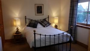 a bedroom with a large bed with two lamps at The Birdcage Guest House in Cornhill-on-tweed
