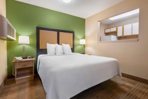 a bedroom with a large bed and a green wall at Extended Stay America Suites - Chicago - O'Hare - Allstate Arena in Des Plaines +34 photos