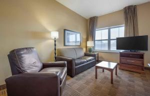 a living room with a couch chair and a flat screen tv at Extended Stay America Suites - Chicago - O'Hare - Allstate Arena in Des Plaines
