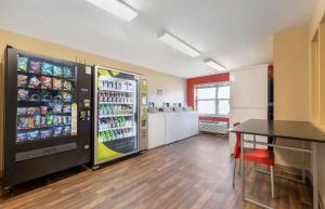 a room with a large refrigerator and a table in it at Extended Stay America Suites - Chicago - O'Hare - Allstate Arena in Des Plaines