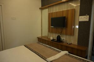 a hotel room with a bed and a television at Hotel Surya Inn in Patna