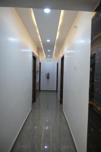 a hallway in a building with white walls and tile floors at Hotel Surya Inn in Patna