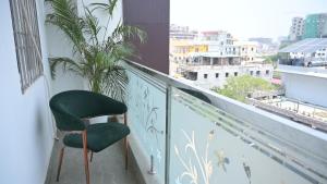 a green chair sitting on top of a balcony at Hotel Surya Inn in Patna