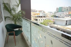 a green chair sitting on a balcony with a view at Hotel Surya Inn in Patna