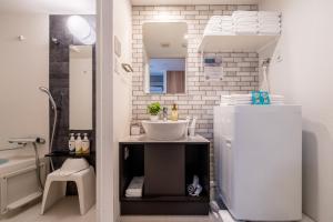 a small bathroom with a sink and a mirror at ESLEAD HOTEL Namba South Ⅲ in Osaka