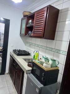 a small kitchen with a sink and a stove at La pépite de Joelle in Douala