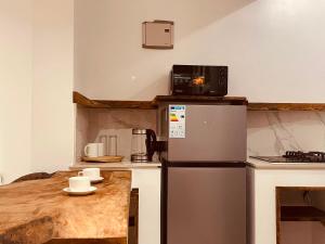 a small kitchen with a refrigerator and a table at Maison Studio indépendante in Nungwi