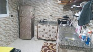 a small kitchen with a sink and a refrigerator at Tamawnza in Aourir