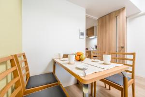 a kitchen and dining room with a wooden table and chairs at ESLEAD HOTEL Namba South Ⅲ in Osaka