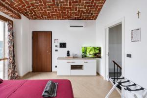 a room with a bed and a desk with a tv at Il Rustico Romantic Suite e Sauna in Ciriè
